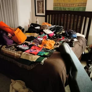 bed strewn with packing for a trip